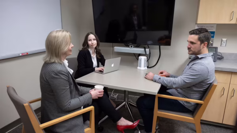 Three people chat in phone room