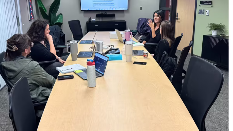Four women talk at conference table