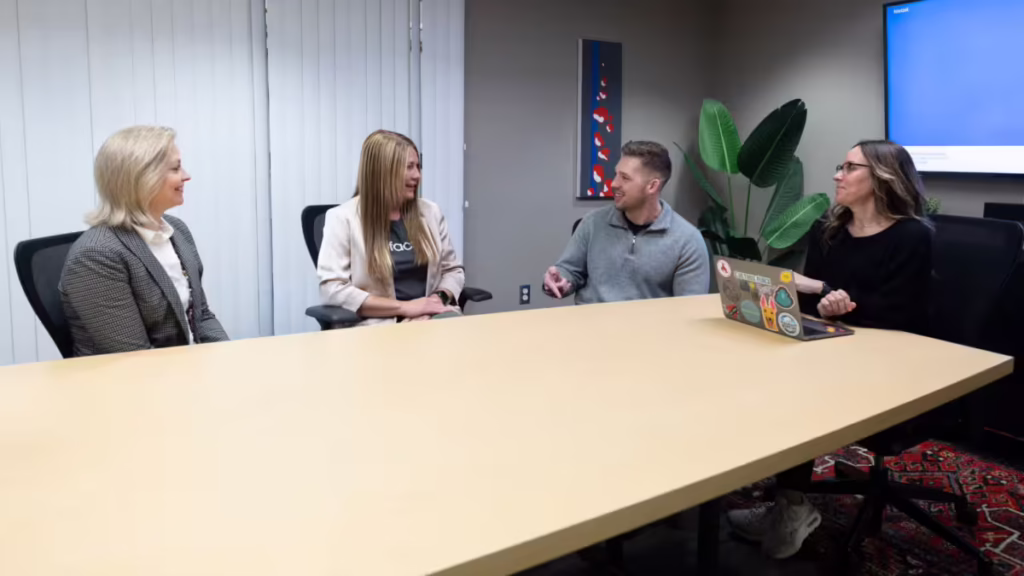 Four people talk in conference room