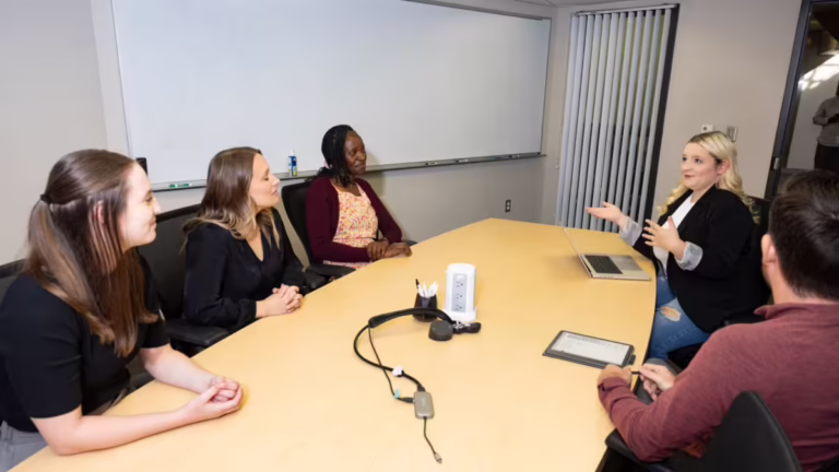 Five people sit in conference space