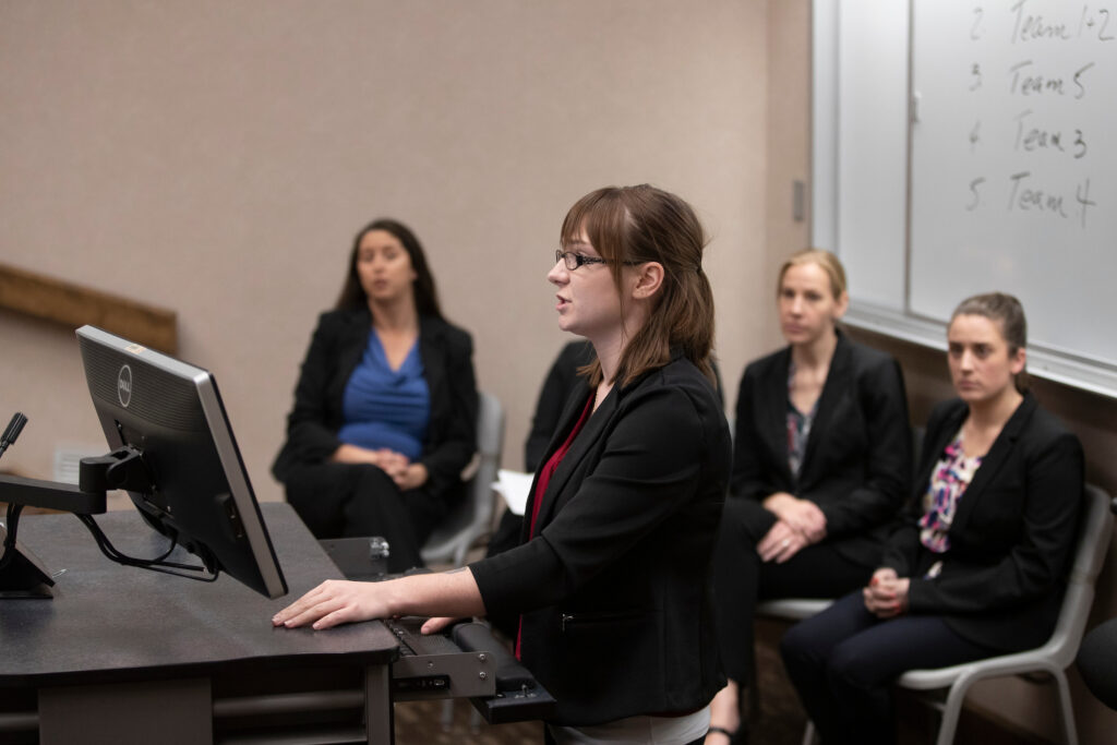 Group of students present to a classroom.