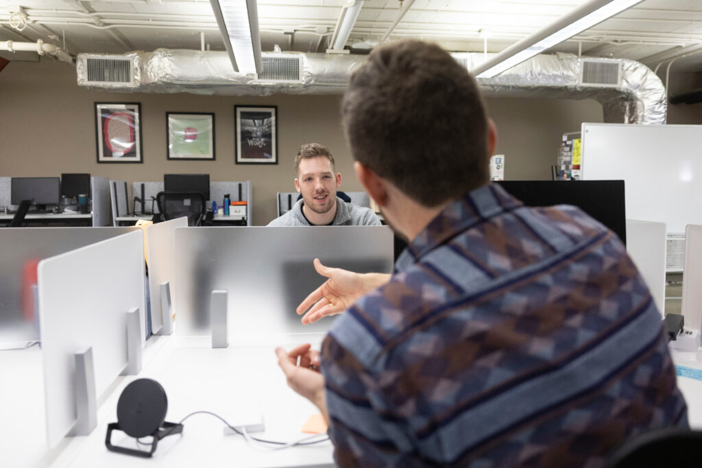 Two men talk in coworking space.