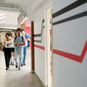 Students walk in school hallway.