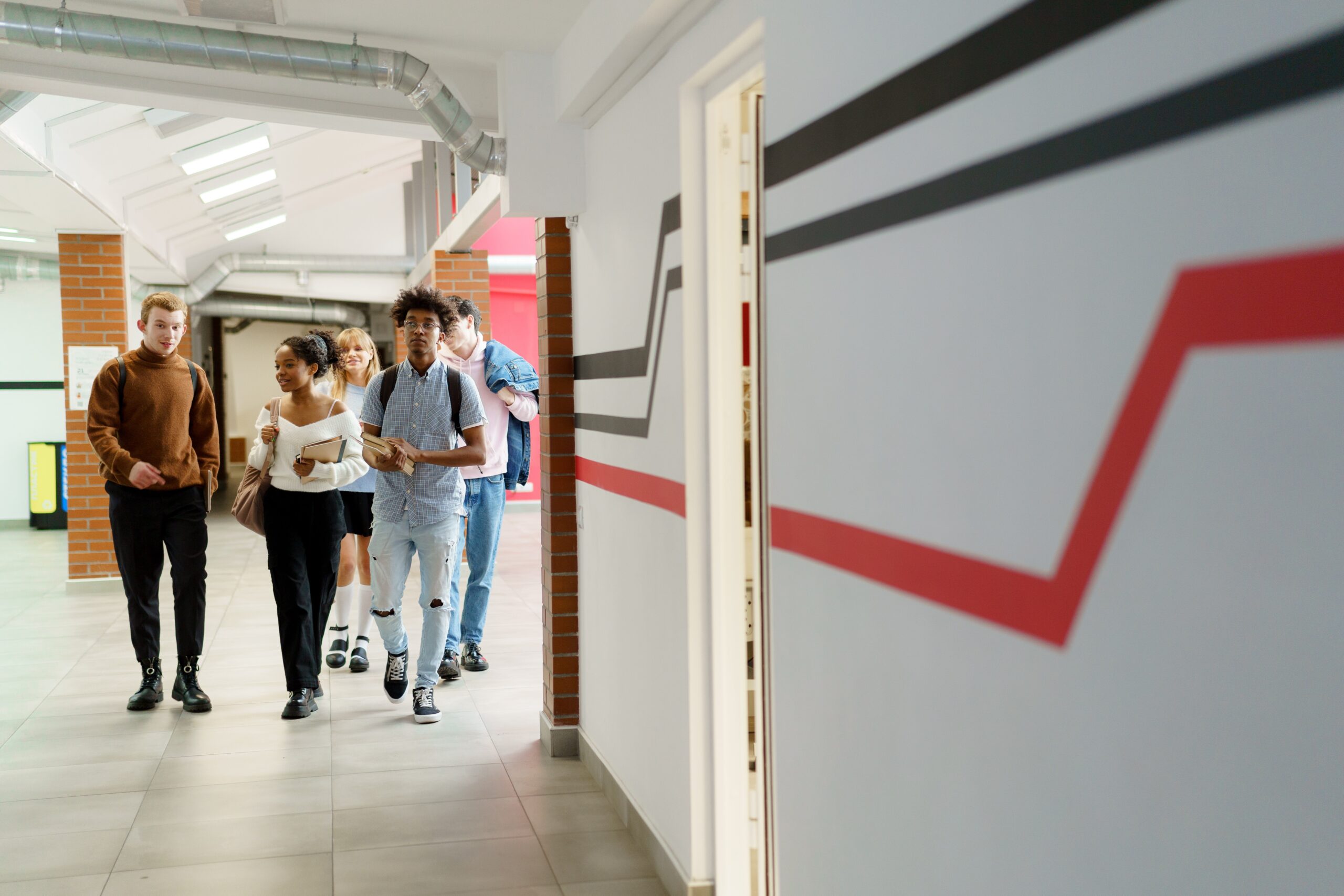 Students walk in school hallway.