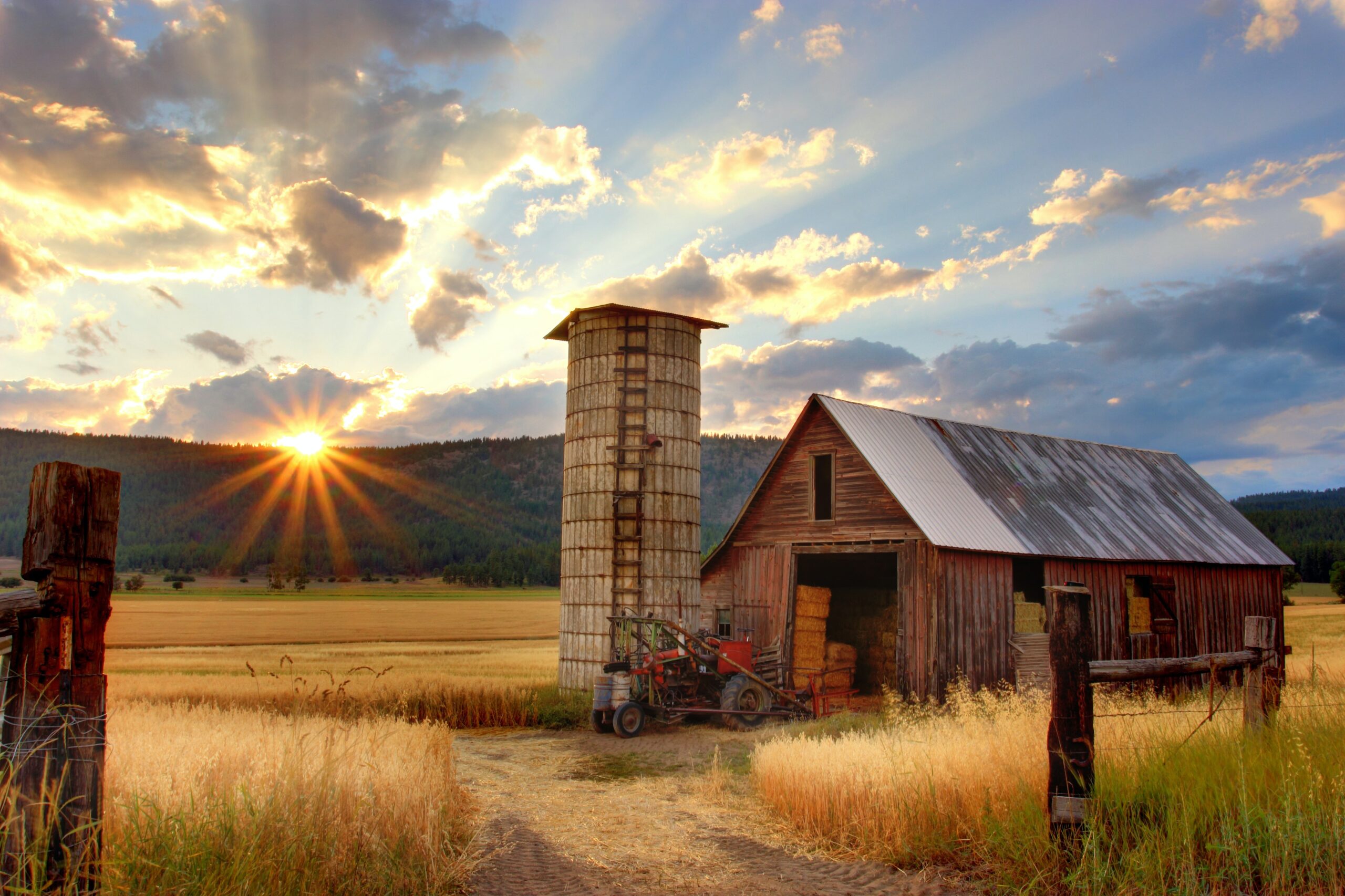 Beautiful picture of a sun setting behind a farm.