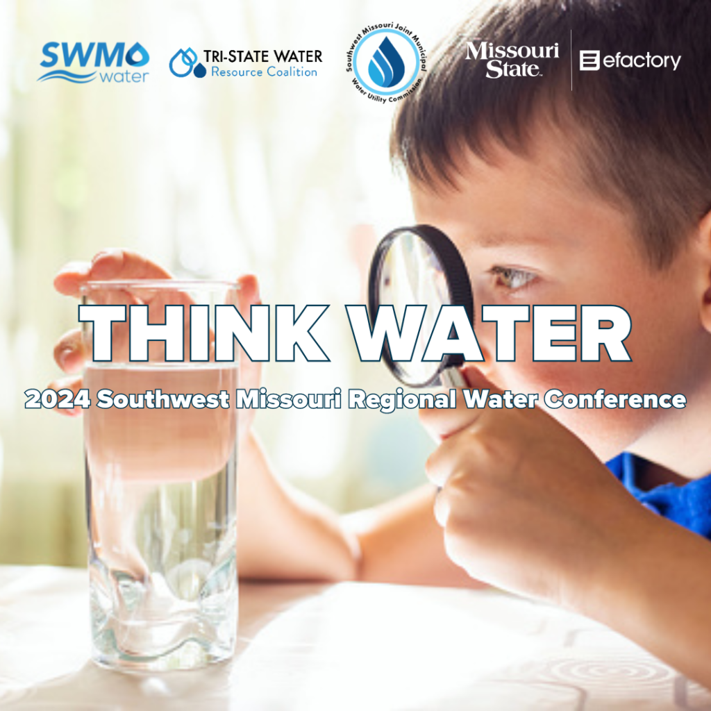 Young boy looking at a clear glass of water through a magnifying glass.