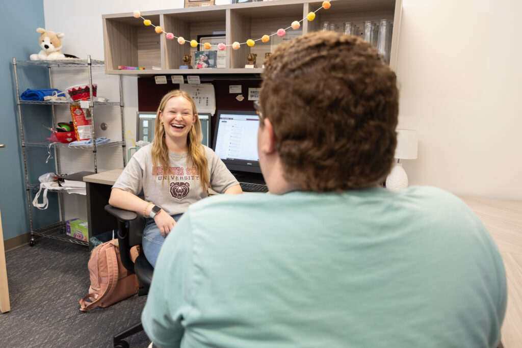 Two student employees chat in their office.