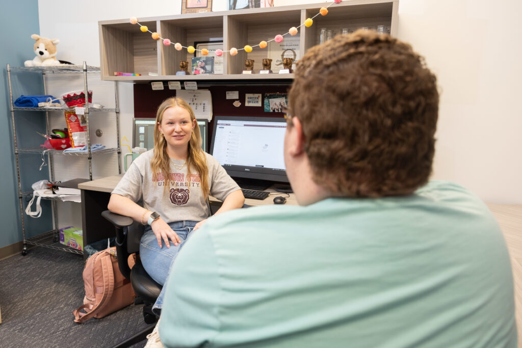 Student employees collaborate in office.