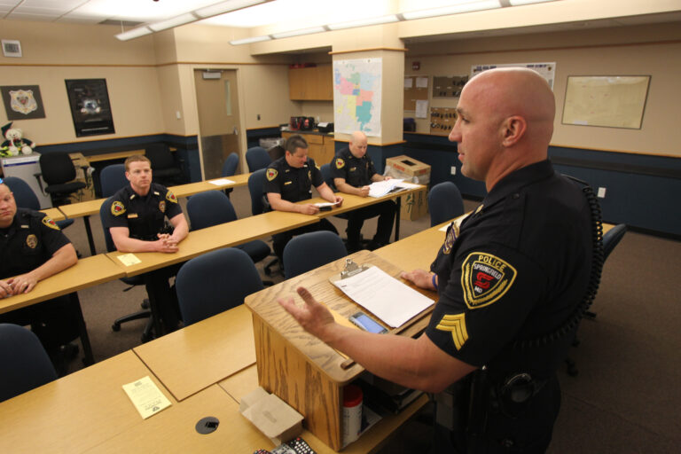 Police officers sit in training space.