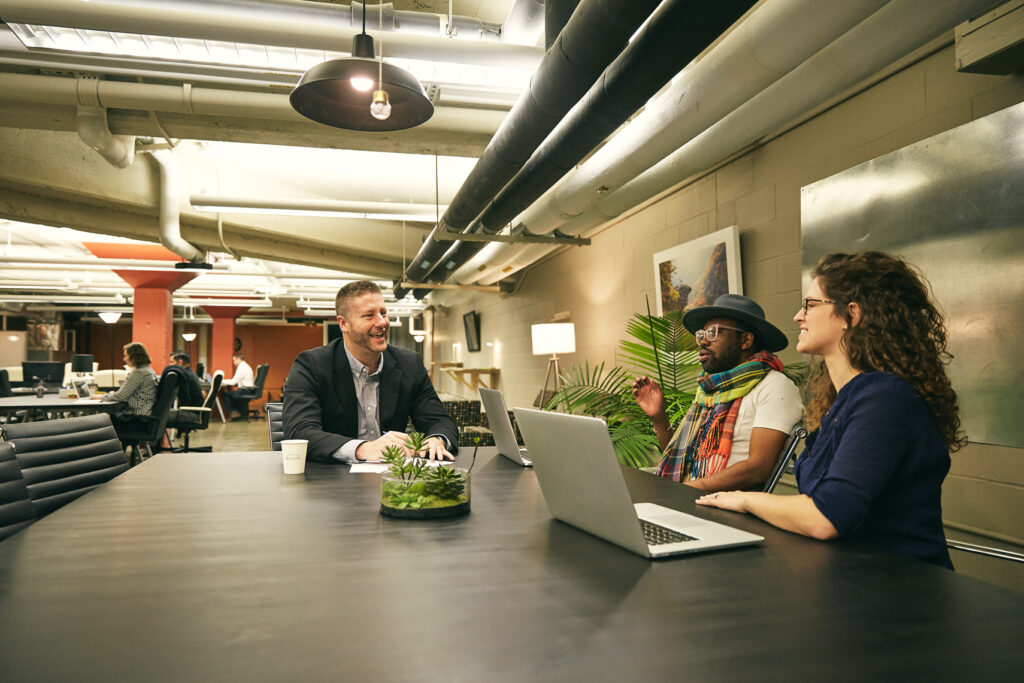 Three people talk at table