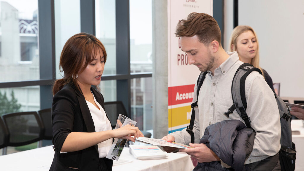 Woman speaks to student at job fair.