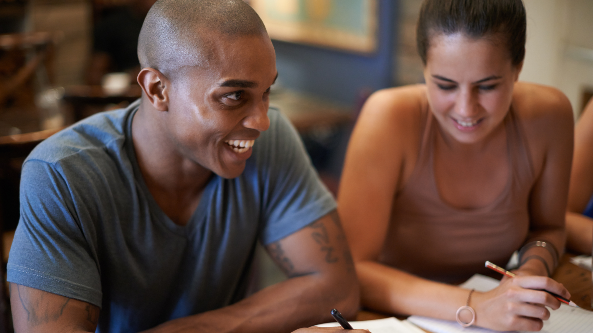 Two people smile doing homework