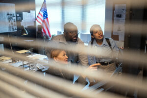 looking through window blinds police officers in room