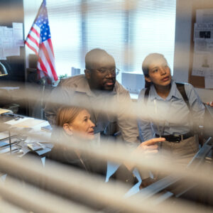 looking through window blinds police officers in room