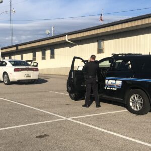 law enforcement stopping car and man standing with hands up under arrest