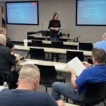 officers sitting in classroom with female instructor teaching