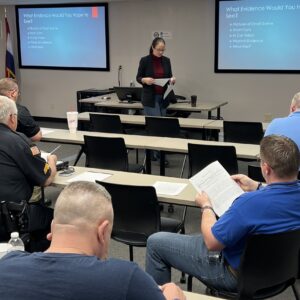 officers sitting in classroom with female instructor teaching