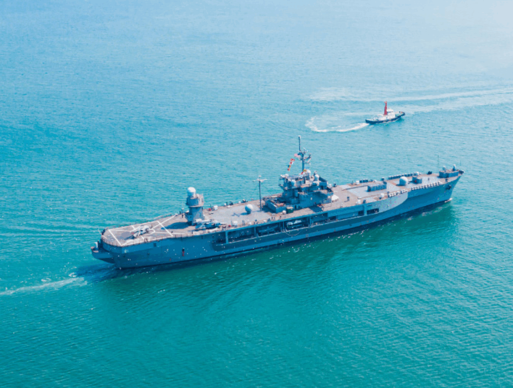 Navy ship on a body of water.