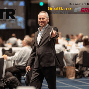 Steve Baker, well known author and speaker presenting to a room full of people. The Great Game of Business, SRC Holdings and Missouri SBDC and Quality Time Remaining (QTR) logos are included.