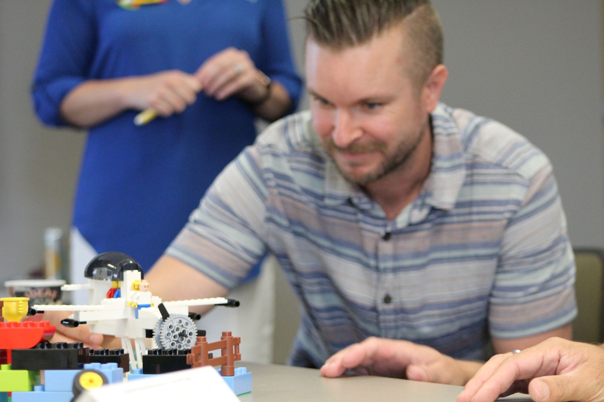 Man sitting behind a LEGO scene with an airplane and LEGO mini-figure.