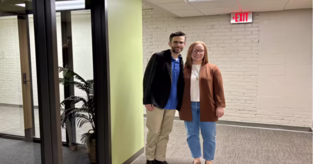 Kylie and Gabriel stand in hallway