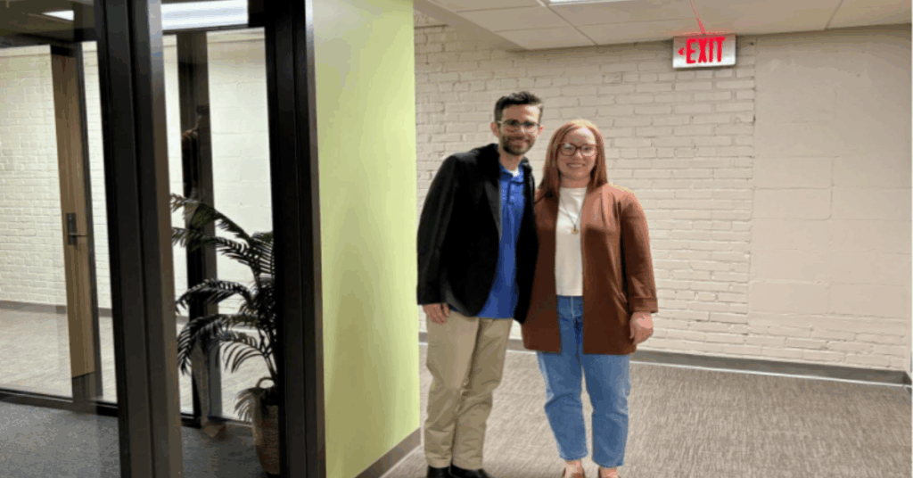 Kylie and Gabriel stand in hallway