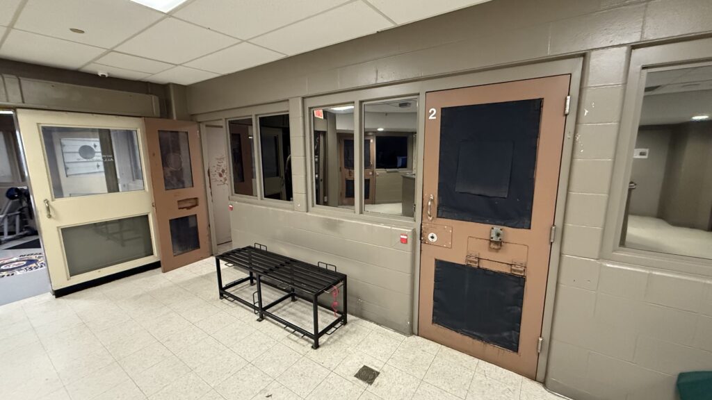 Looking inside at a jail cell with open doors