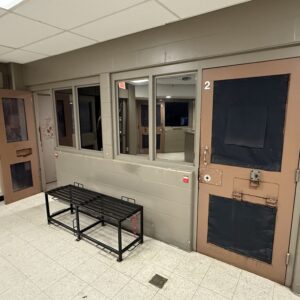 Looking inside at a jail cell with open doors