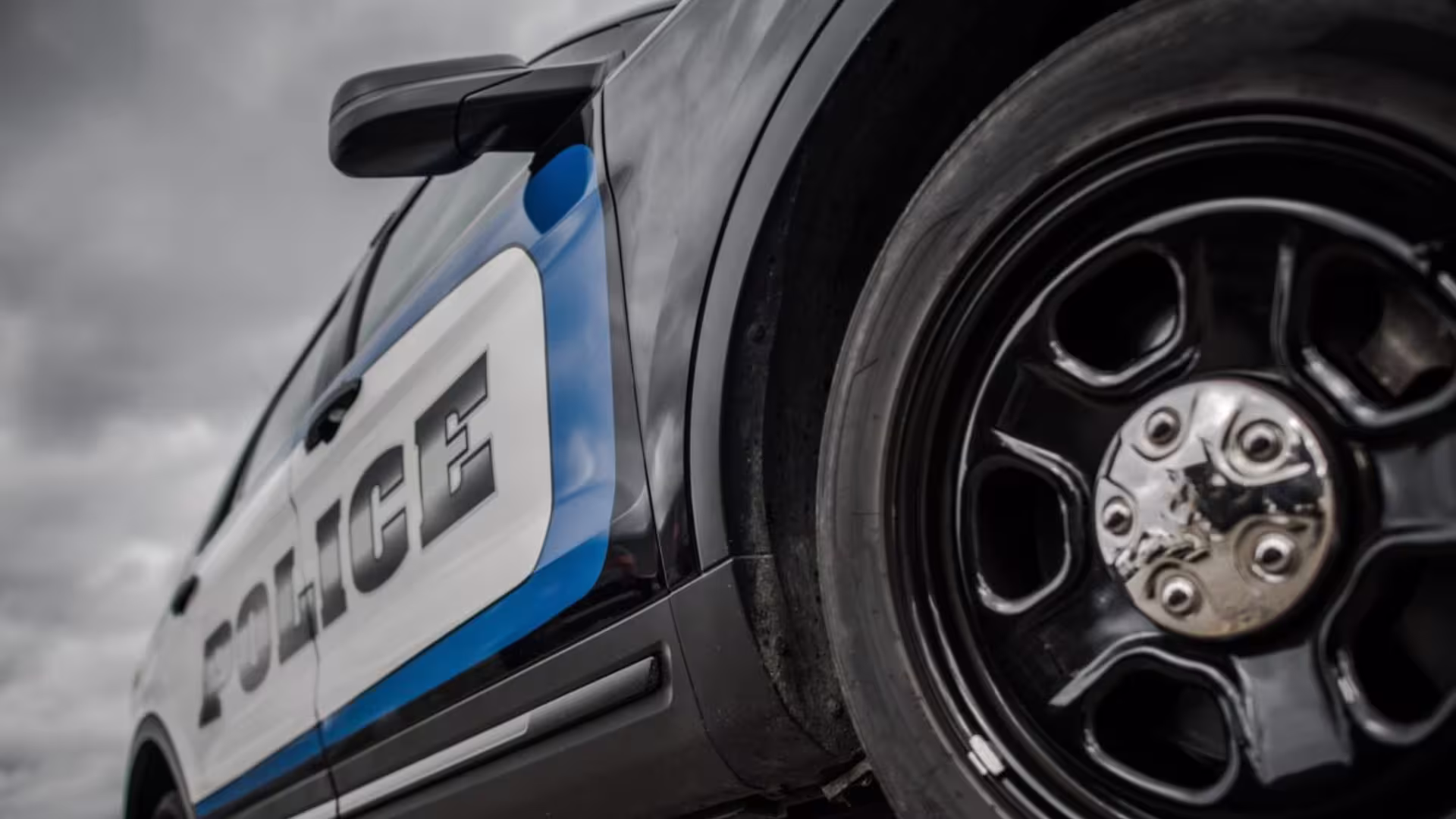 picture of police car close up with wheel and door staying police