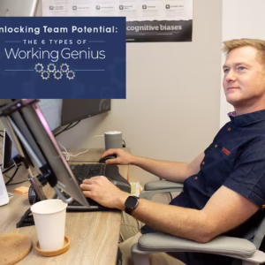 Man sitting at his work desk looking a text box that reads "Unlocking Team Potential: The 6 Types of Working Genius" and has the Working Genius logo.