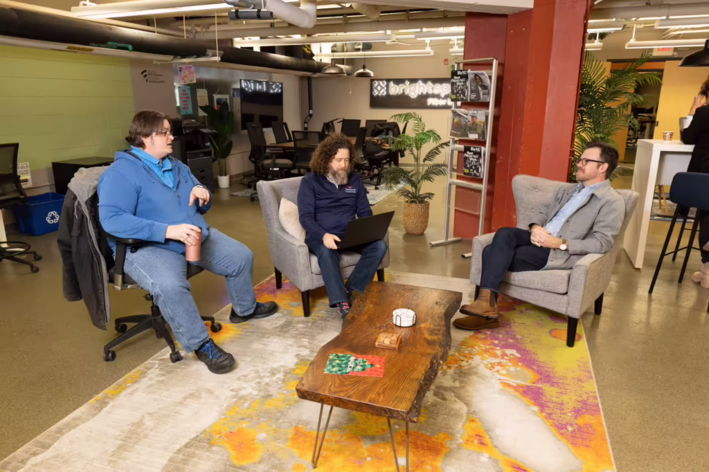 Three men talk in coworking