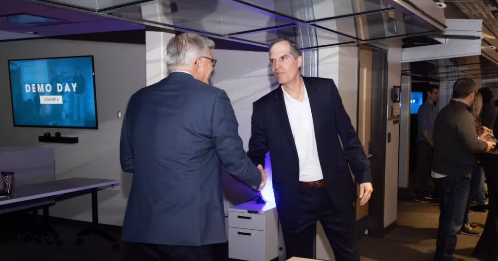 Allen shakes hands with a man in a suit