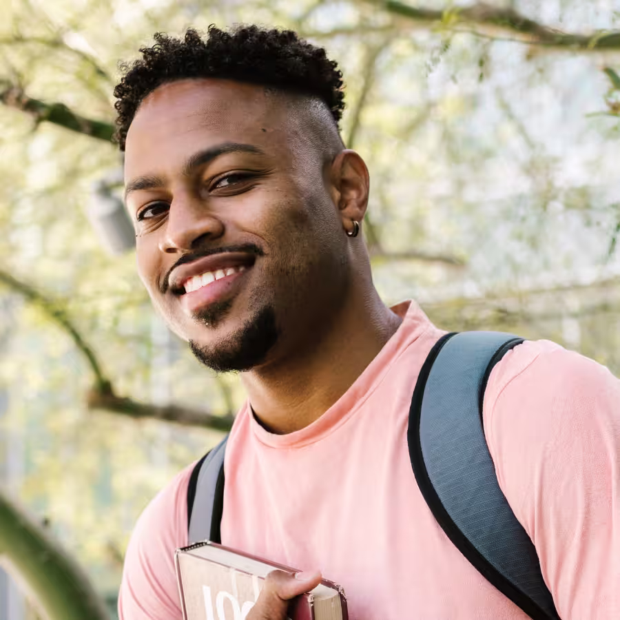 Young man smiles wearing a backpack