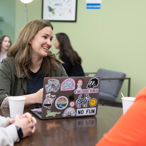 Women sit in coffee shop with laptop.
